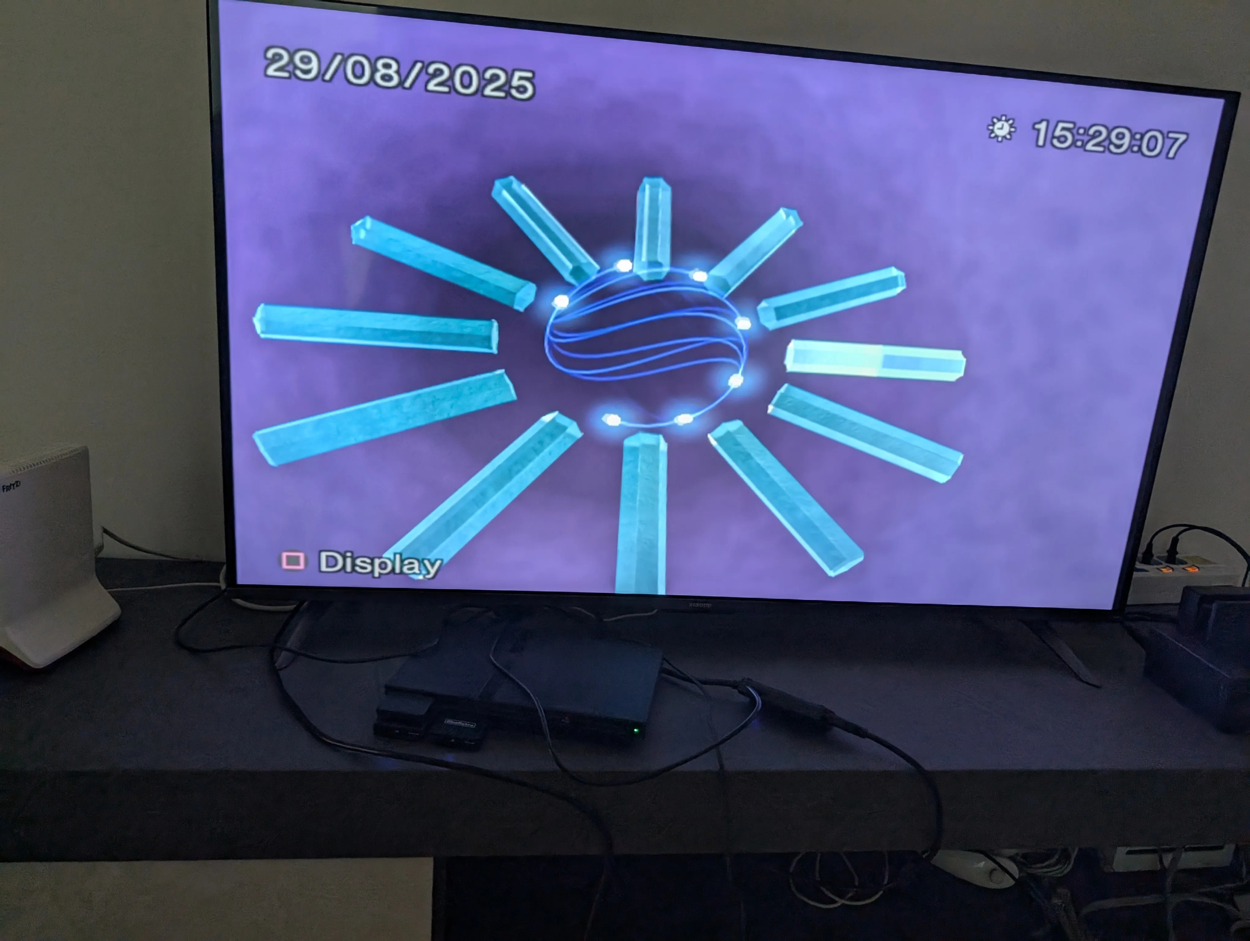 The PlayStation 2 setup, complete inside my living room. The TV is showing the iconic PlayStation 2 clock animation.